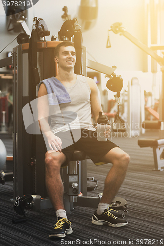 Image of smiling man exercising on gym machine