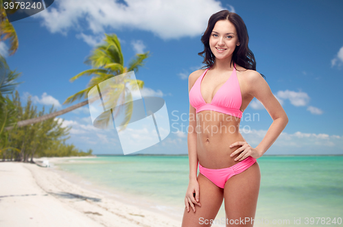 Image of happy woman in pink bikini swimsuit on beach