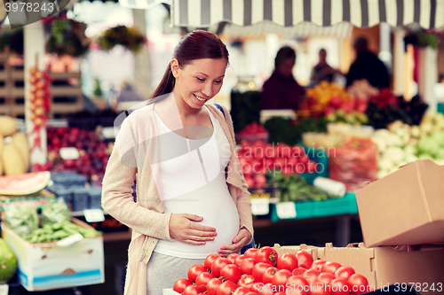 Image of pregnant woman choosing food at street market