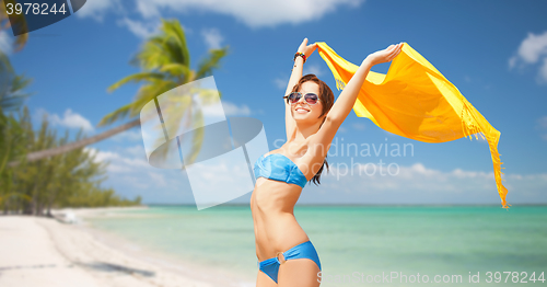 Image of woman in bikini and sunglasses over tropical beach