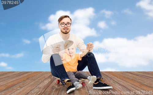 Image of happy father and little son on skateboard