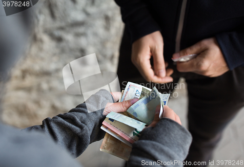 Image of close up of addict buying dose from drug dealer