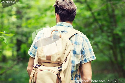 Image of young man with backpack hiking in woods