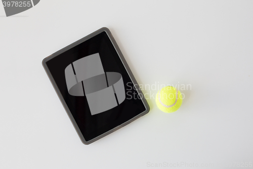 Image of close up of tennis ball and tablet pc over white