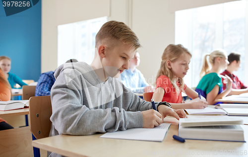 Image of group of students with books writing school test