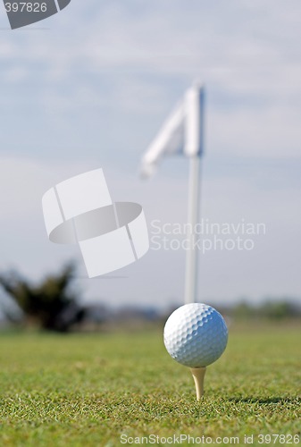 Image of Golf ball in tall green grass set against blue sky