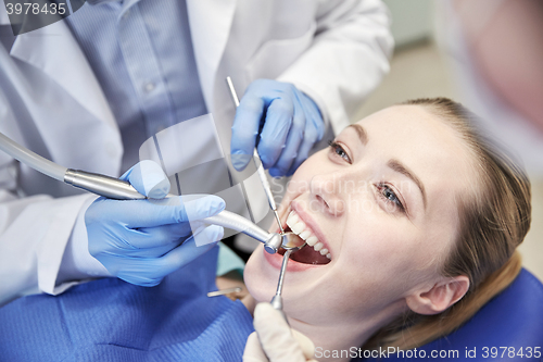 Image of close up of dentist treating female patient teeth