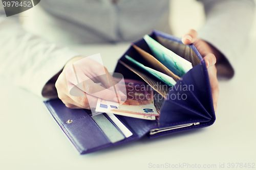 Image of close up of woman hands with wallet and euro money