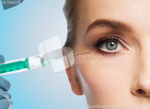 Image of woman face and hand with syringe making injection