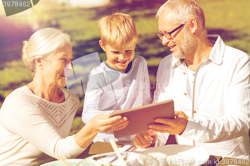 Image of happy family with tablet pc outdoors