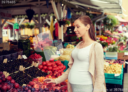 Image of pregnant woman choosing food at street market