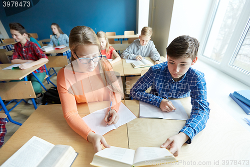 Image of students reading book at school lesson