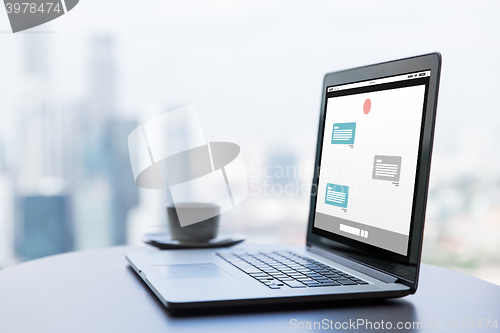 Image of close up of laptop and coffee cup on office table