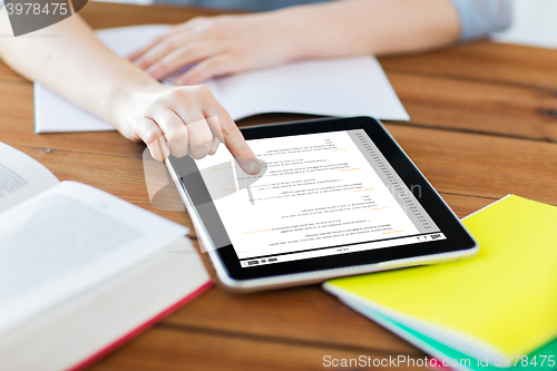 Image of close up of student with tablet pc and notebook