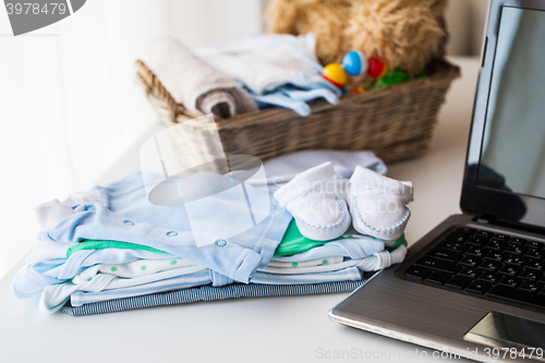 Image of close up of baby clothes, toys and laptop