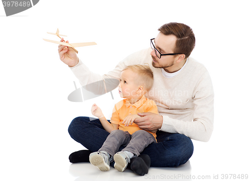 Image of father and little son playing with toy airplane