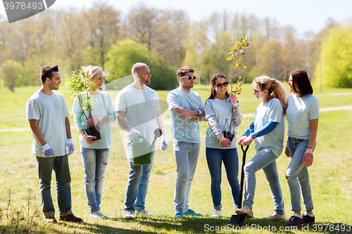 Image of group of volunteers with trees and rake in park