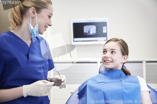 Image of female dentist checking patient girl teeth