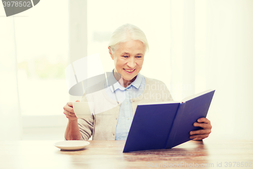 Image of happy smiling senior woman reading book at home