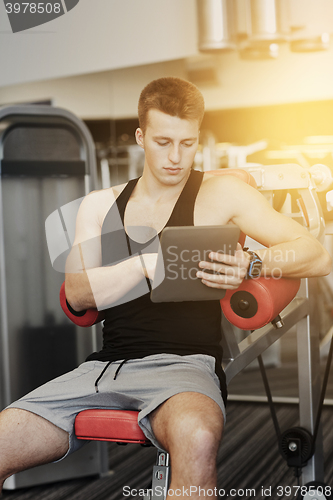 Image of young man with tablet pc computer in gym