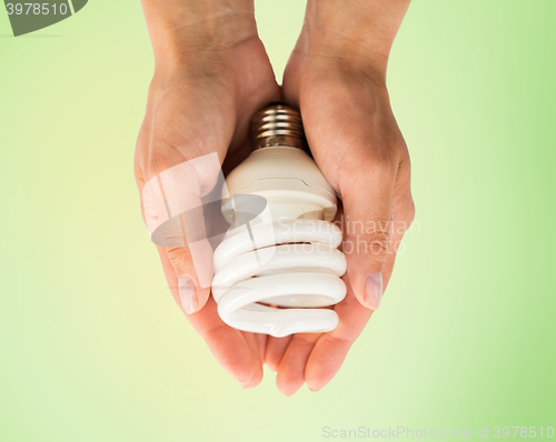 Image of close up of hands holding energy saving lightbulb