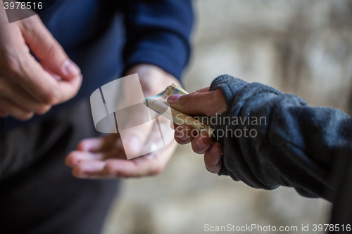 Image of close up of addict buying dose from drug dealer