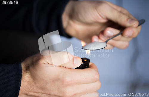 Image of close up of addict preparing crack cocaine drug