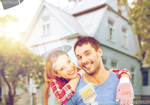 Image of smiling couple covered with paint with paint brush