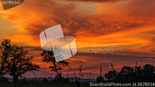 Image of Landscape with dark orange and yellow stormy cloudy sky