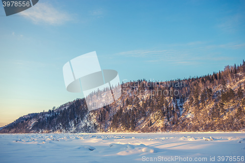 Image of winter landscape of snow-covered fields, trees 