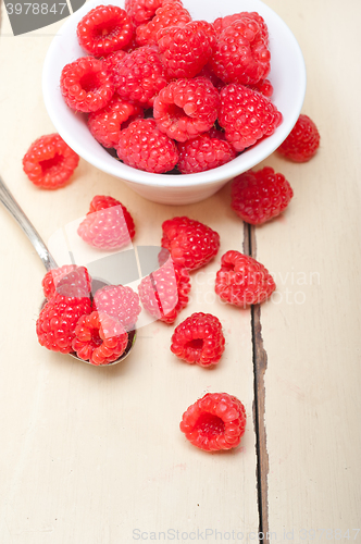 Image of bunch of fresh raspberry on a bowl and white table