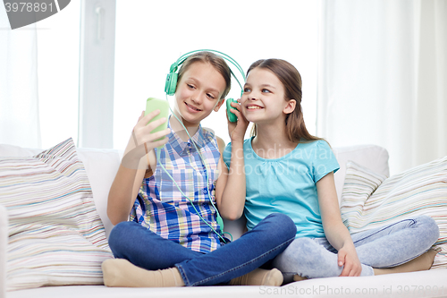 Image of happy girls with smartphone and headphones