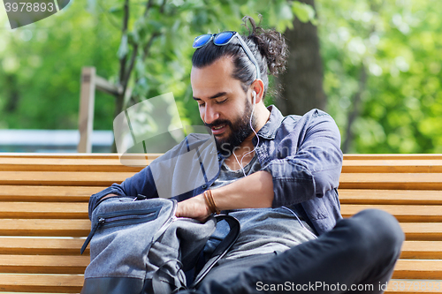 Image of man with backpack and earphones in city