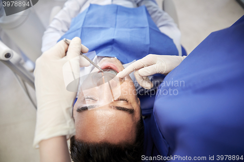 Image of close up of dentist checking male patient teeth