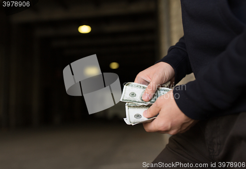 Image of close up of addict or drug dealer hands with money