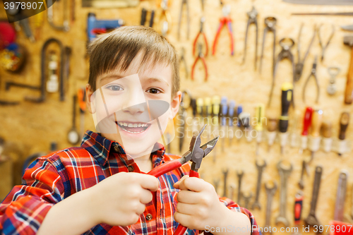 Image of happy little boy with pliers at workshop