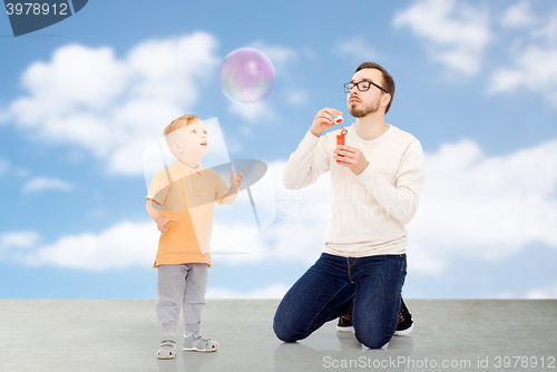 Image of father with son blowing bubbles and having fun