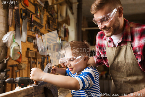 Image of father and son with plane shaving wood at workshop