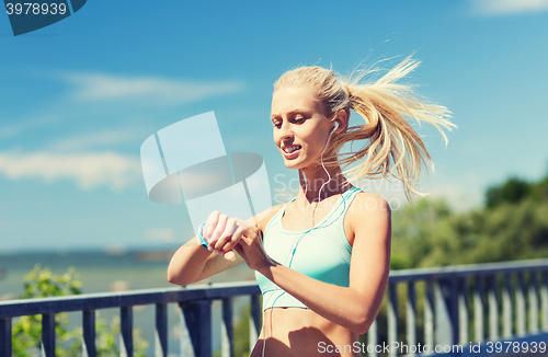 Image of happy woman with heart rate watch and earphones