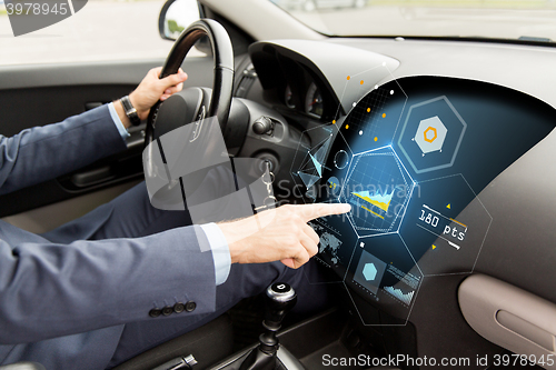 Image of close up of man driving car with diagram on screen