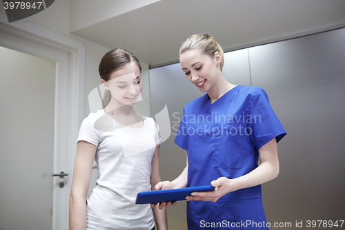 Image of smiling nurse with tablet pc and girl at hospital