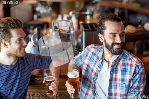 Image of happy male friends drinking beer at bar or pub