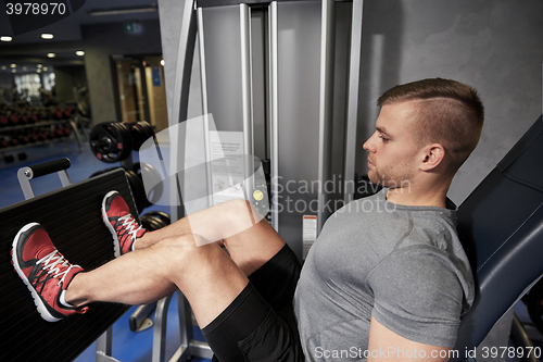 Image of man flexing leg muscles on gym machine