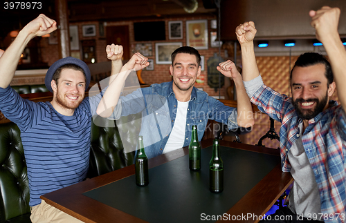 Image of happy male friends drinking beer at bar or pub