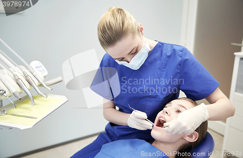 Image of female dentist checking patient girl teeth