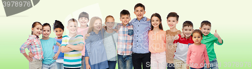 Image of group of happy smiling children hugging over green
