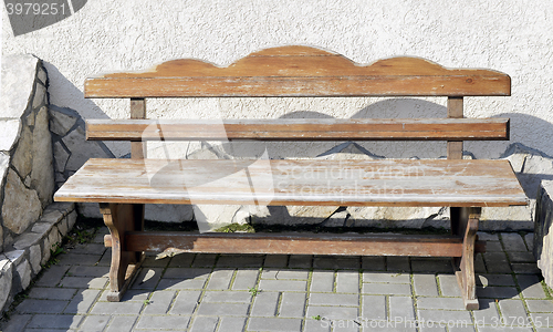 Image of Old wooden vintage empty bench standing on an open paved area