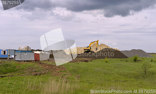 Image of  Yellow excavator working digging in sand quarry