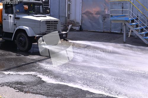 Image of Water truck watering the asphalt at a manufacturing plant for du