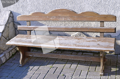 Image of Old wooden vintage empty bench standing on an open paved area